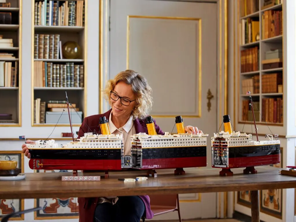 Person assembling large ship model indoors