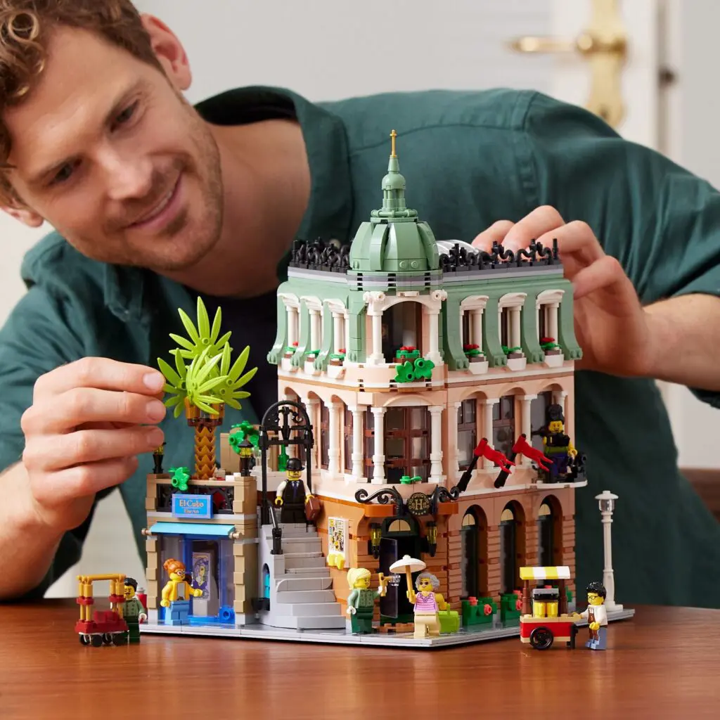 Man assembling detailed Lego building set