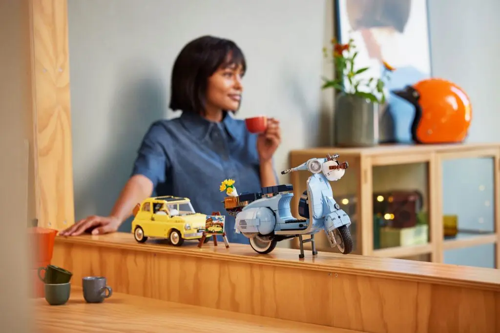 Woman drinking coffee near toy scooter