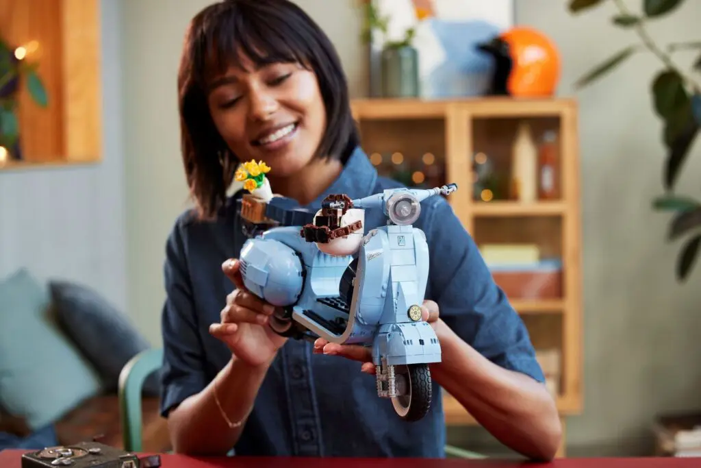 Person assembling a blue toy scooter
