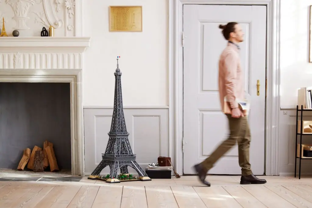 Man walking past Eiffel Tower model indoors.