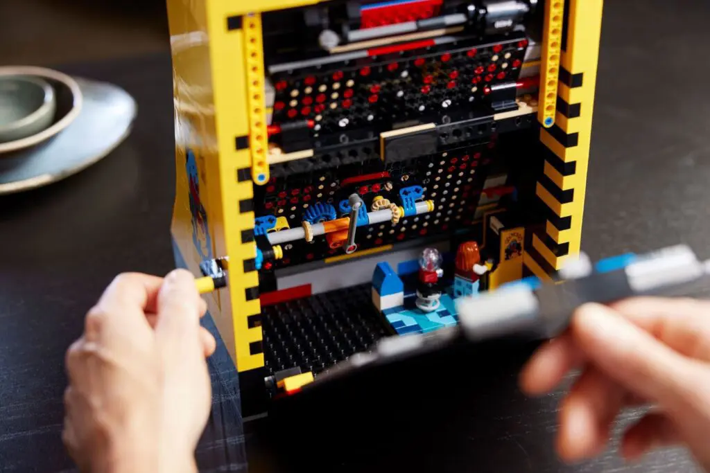 Hands assembling colorful LEGO structure