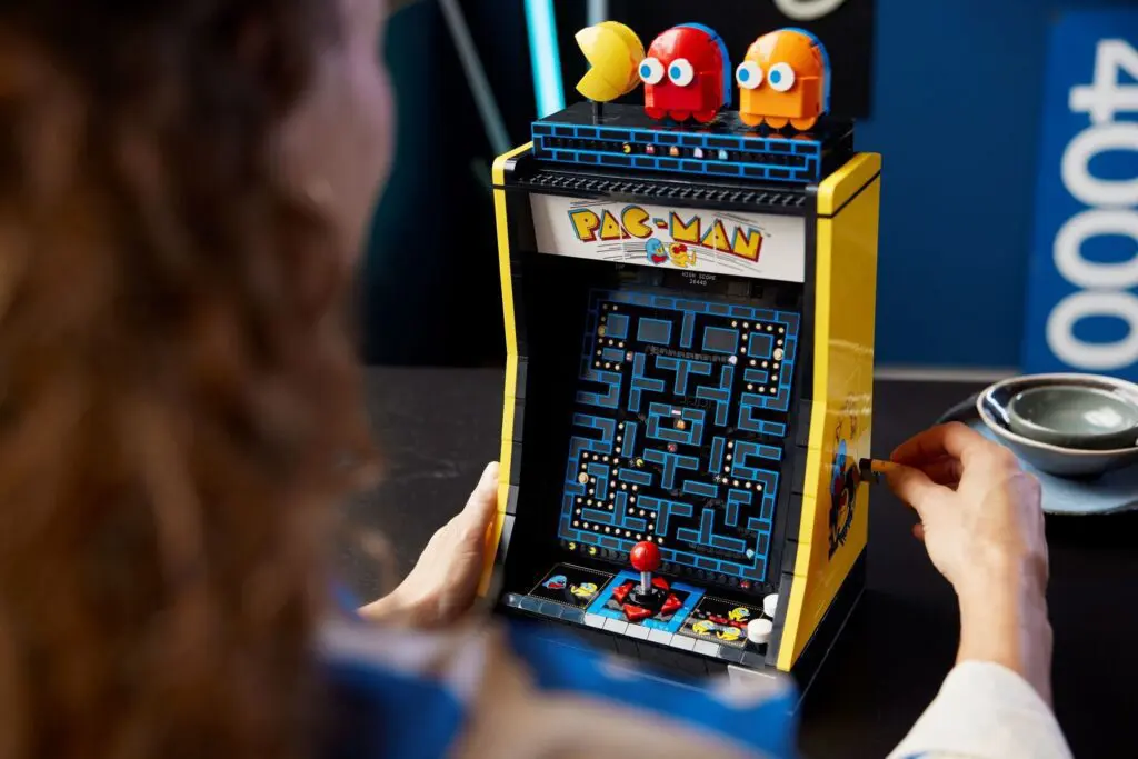 Person enjoying a Pac-Man arcade machine