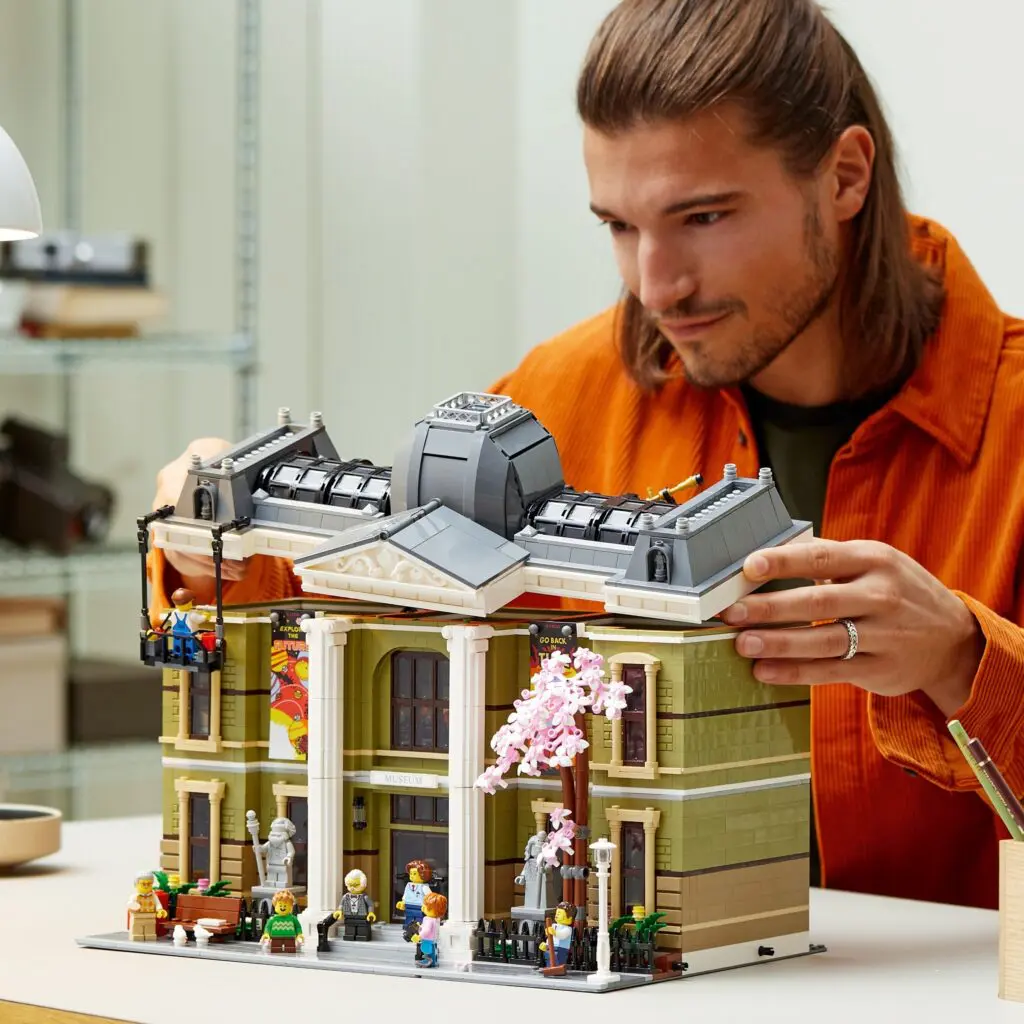 Man constructing intricate LEGO structure