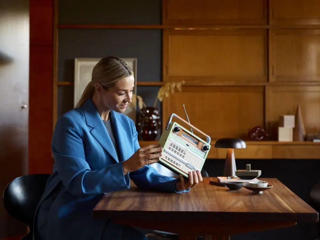 Woman in blue suit with old radio