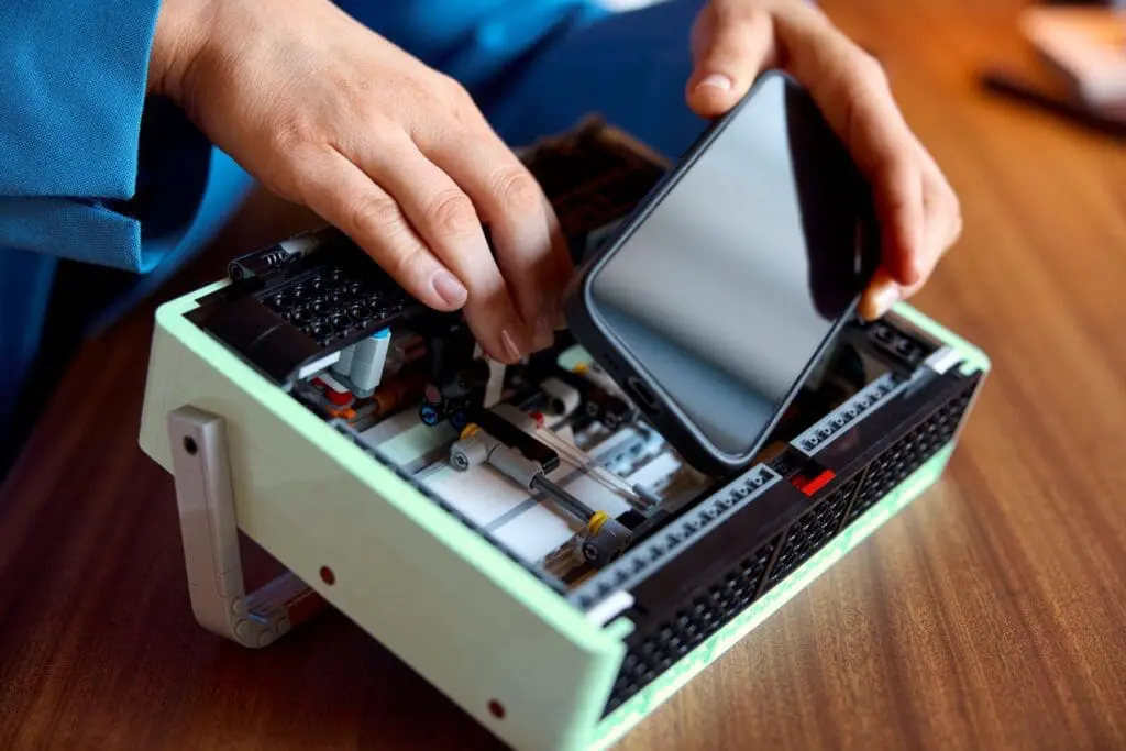 Hands assembling a device with phone screen