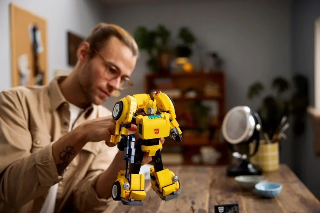 Person building a yellow robot model