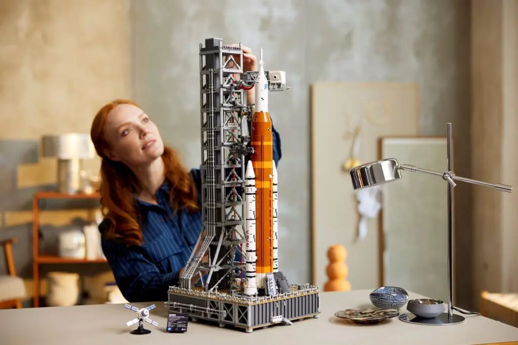 Person adjusting intricate spacecraft model assembly