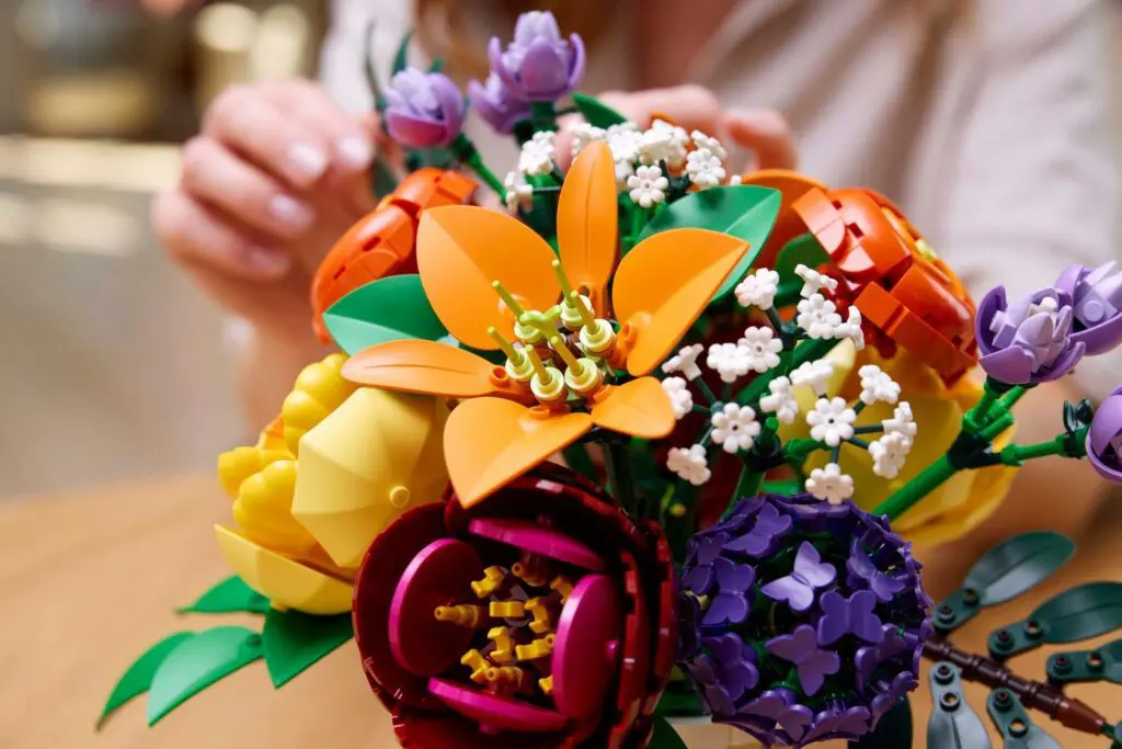 Hands crafting LEGO flowers bouquet