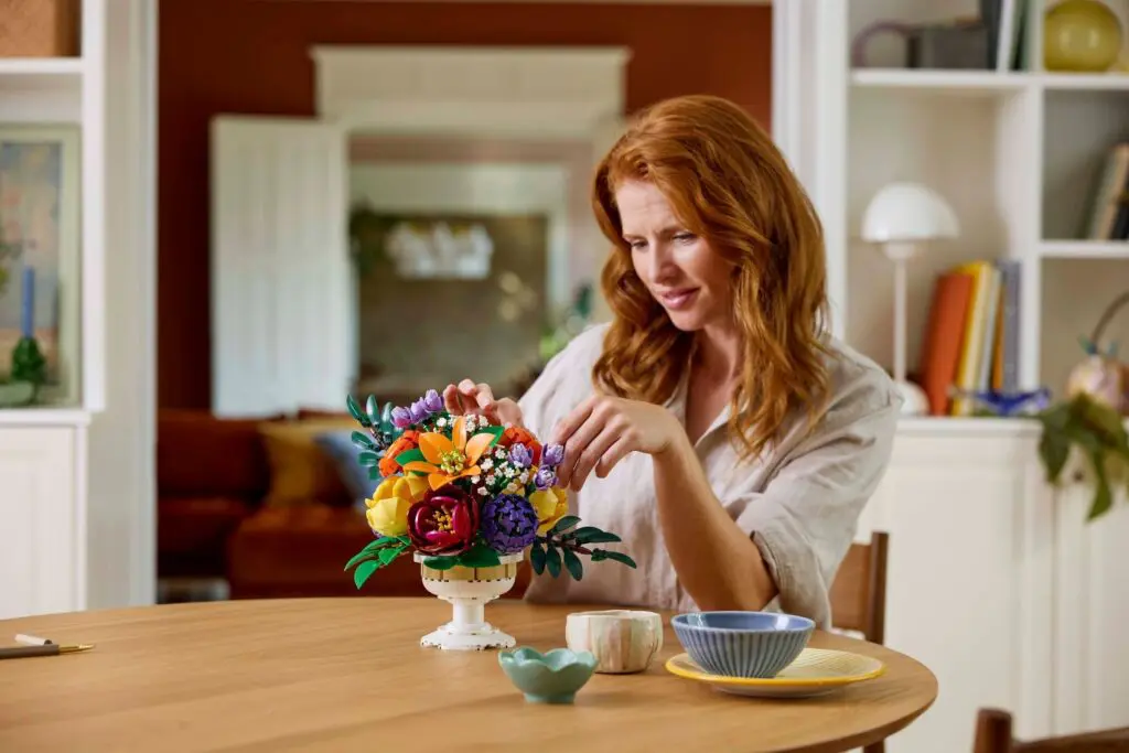 Red-haired woman decorating floral arrangement