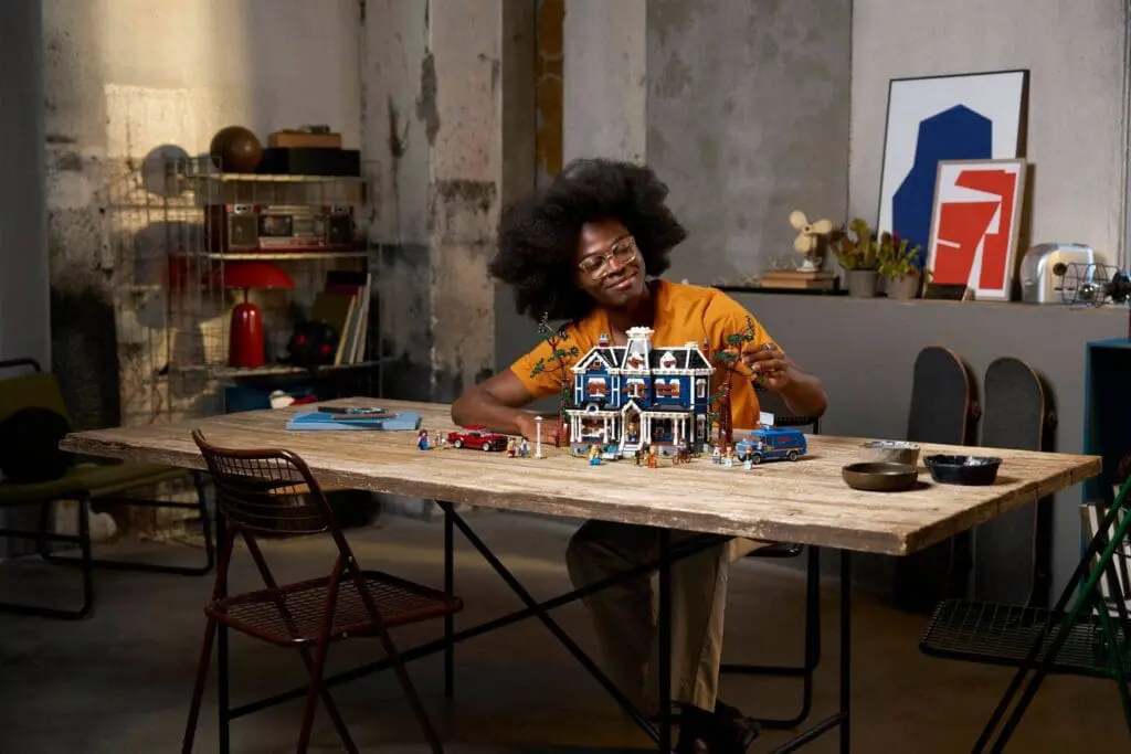 Person building a model house indoors