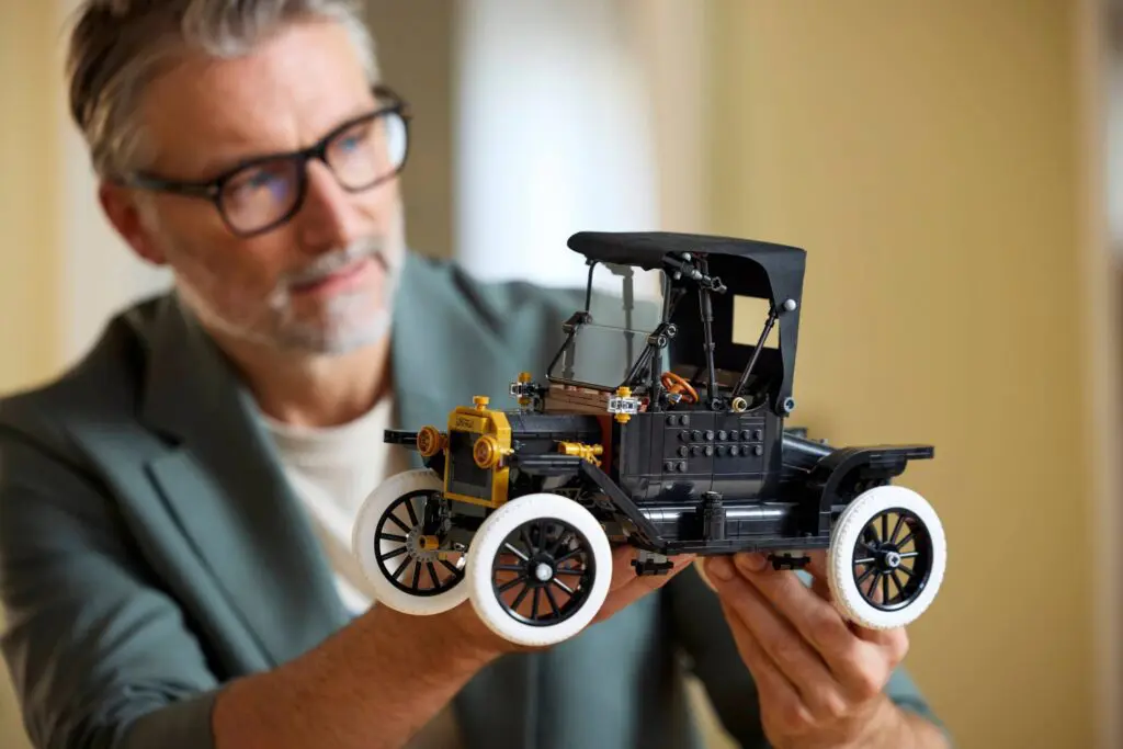 Person examining miniature antique vehicle