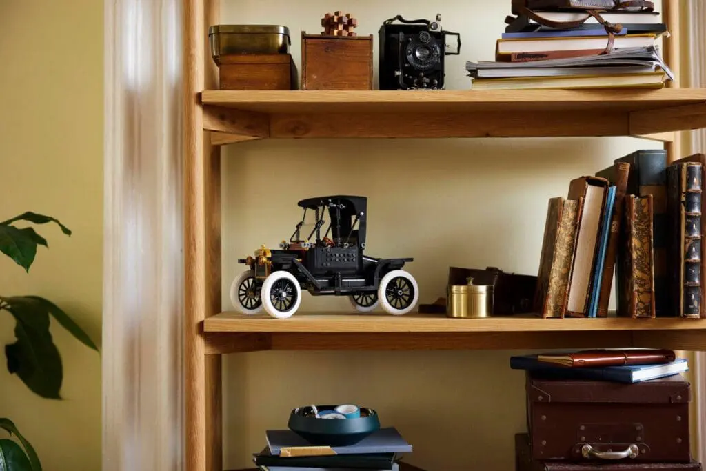 Model car and camera on wooden shelf