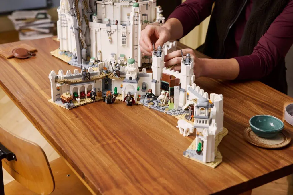 Hands assembling a detailed Lego structure