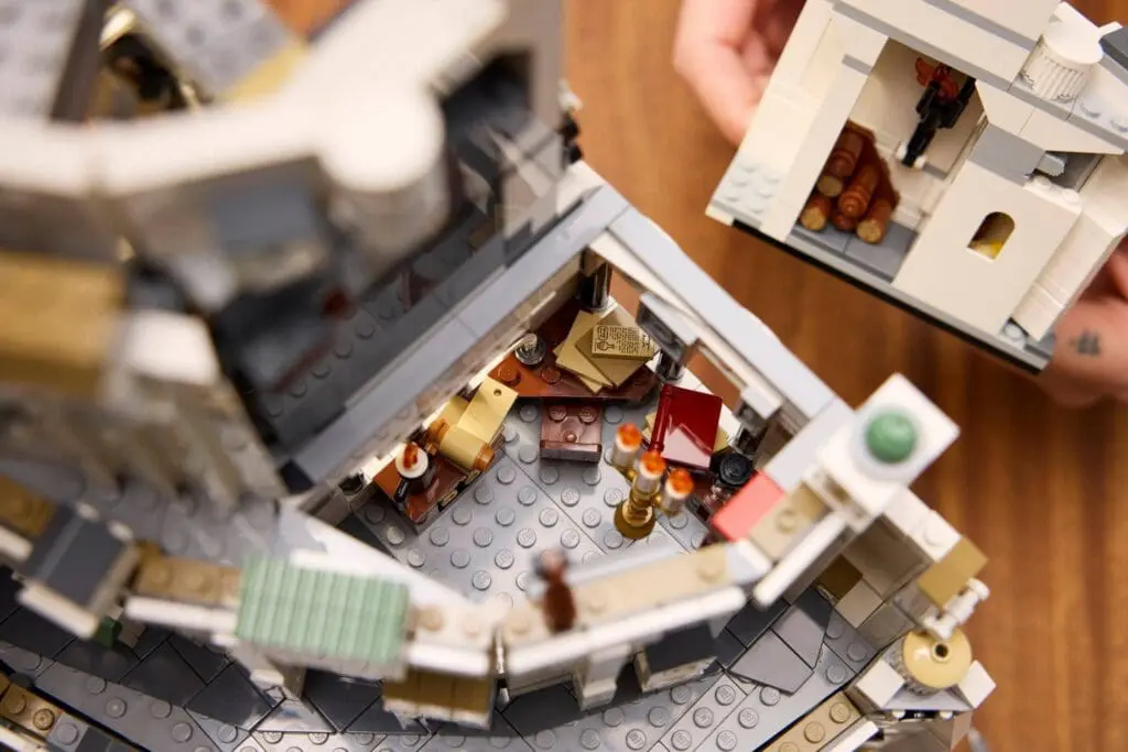 Hands assembling intricate LEGO structure