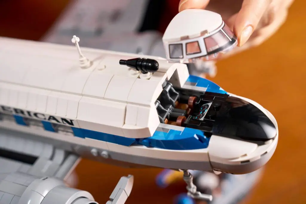 Hand lifting cockpit off LEGO spaceship model