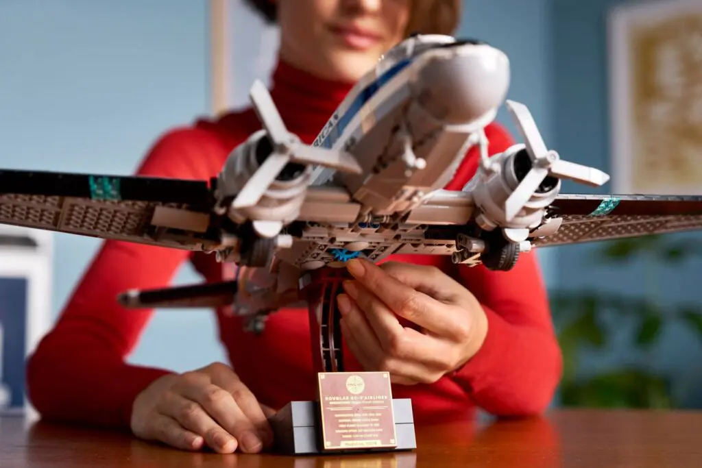 Person adjusting model airplane on stand