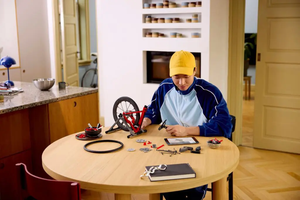 Person assembling bicycle wheel at table