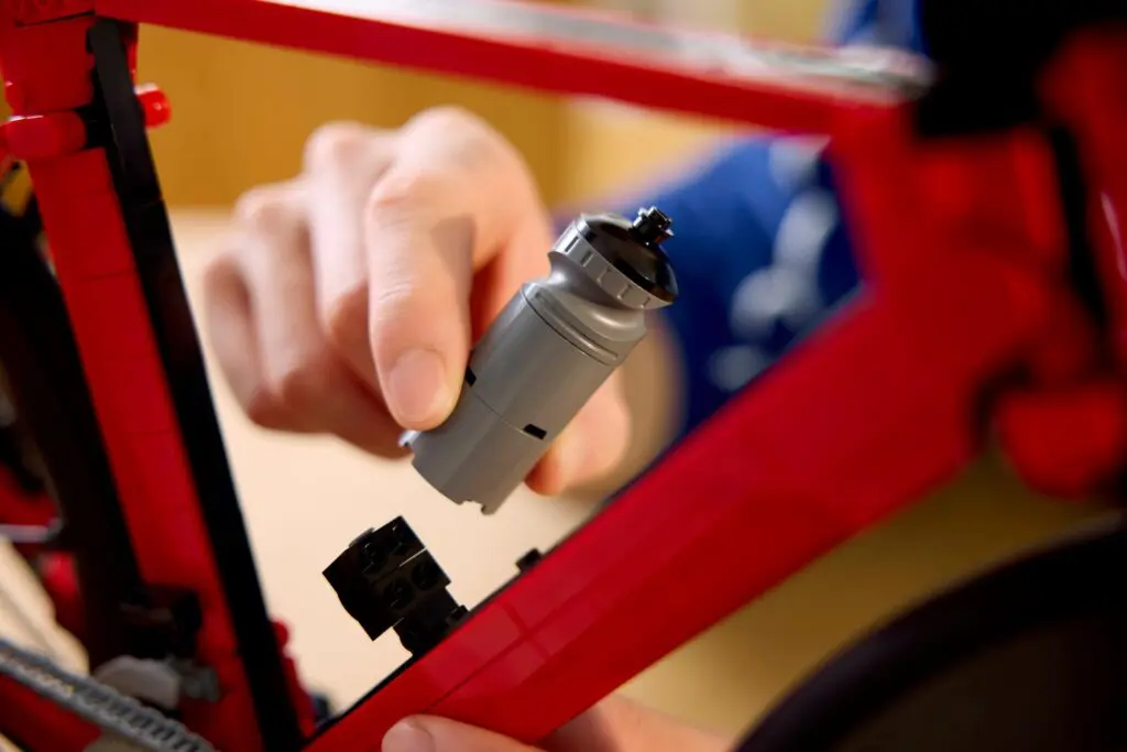 Assembling a red plastic bicycle