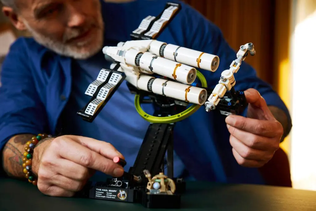 Hands assembling detailed spacecraft model