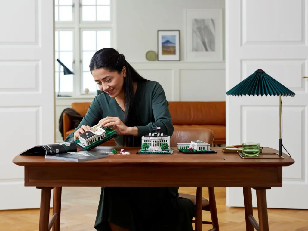 Woman building architectural model at desk