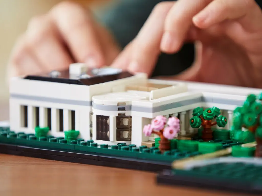 Person constructing a Lego house model