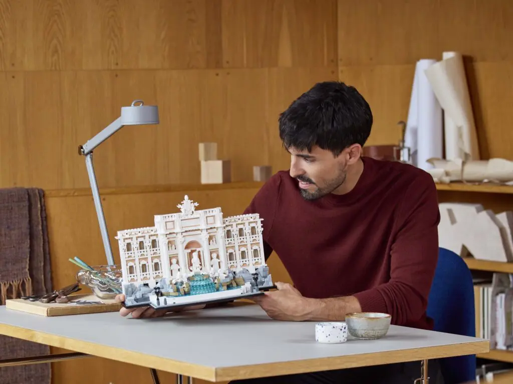 Man examining architectural model on desk