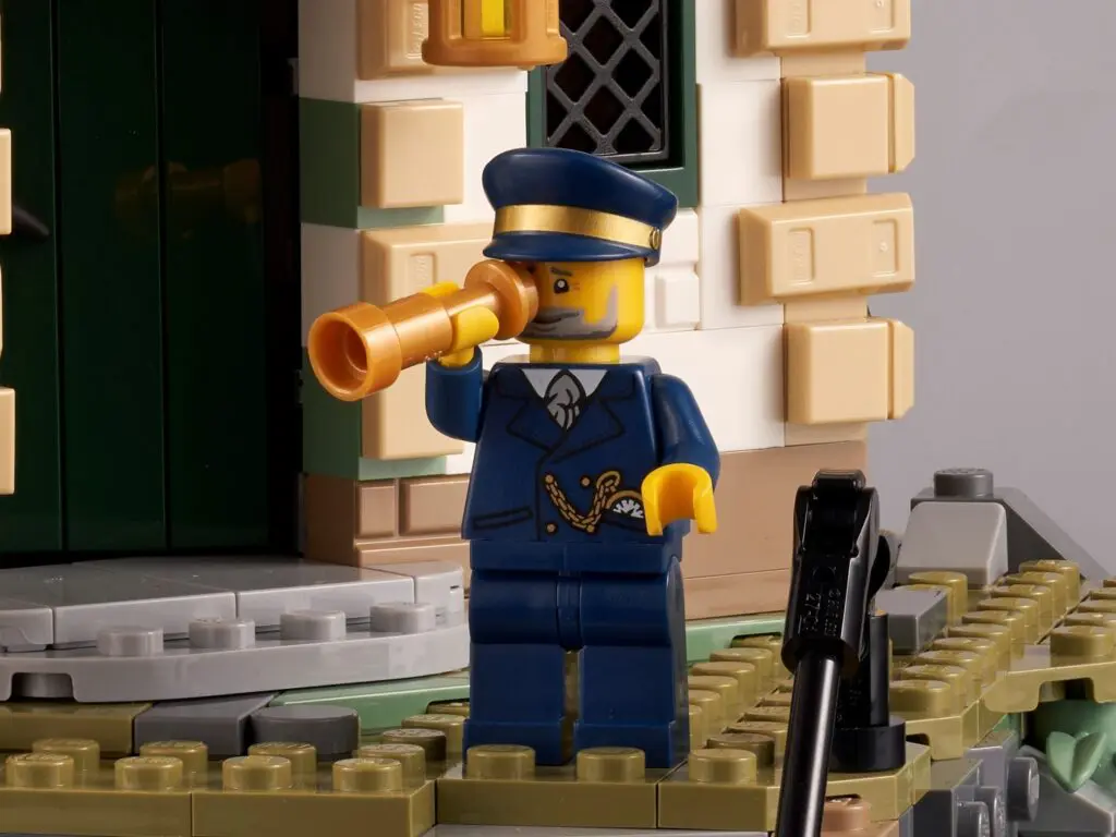 Lego figure with telescope outside building