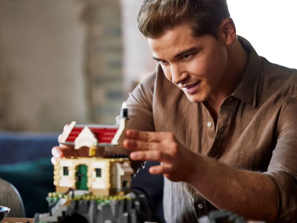 Concentrated man assembling miniature house