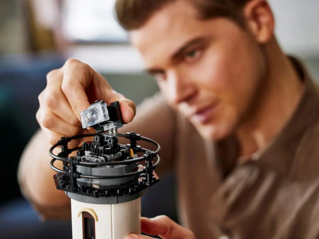 Person assembling a LEGO lighthouse model