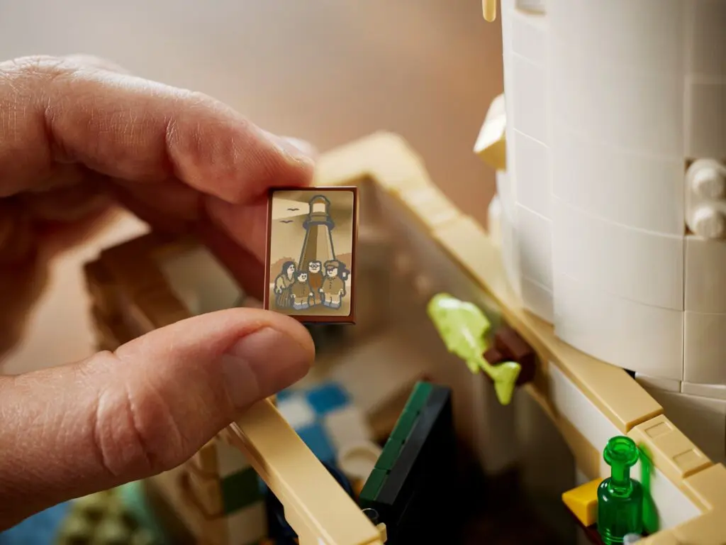 Hand holding small illustrated LEGO tile