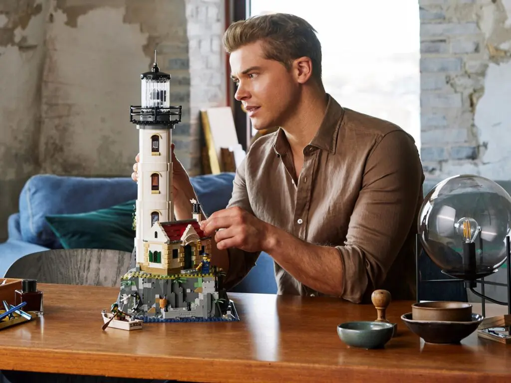 Man assembling a detailed lighthouse model