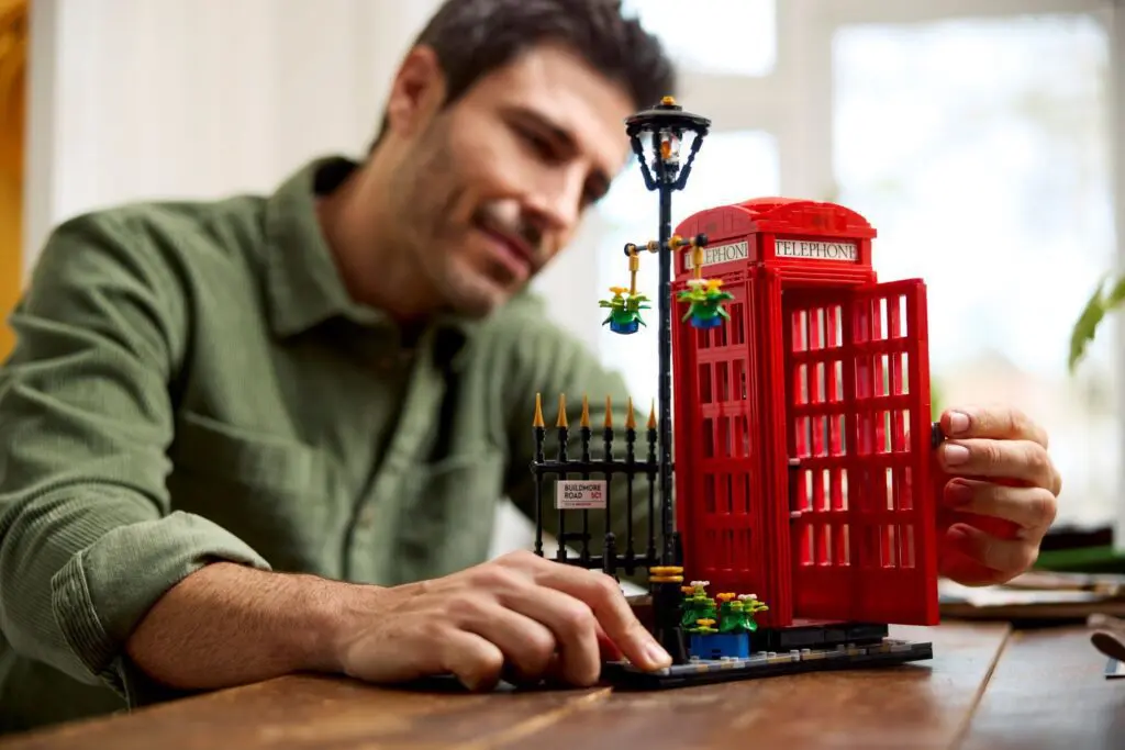 Man assembling red telephone booth model