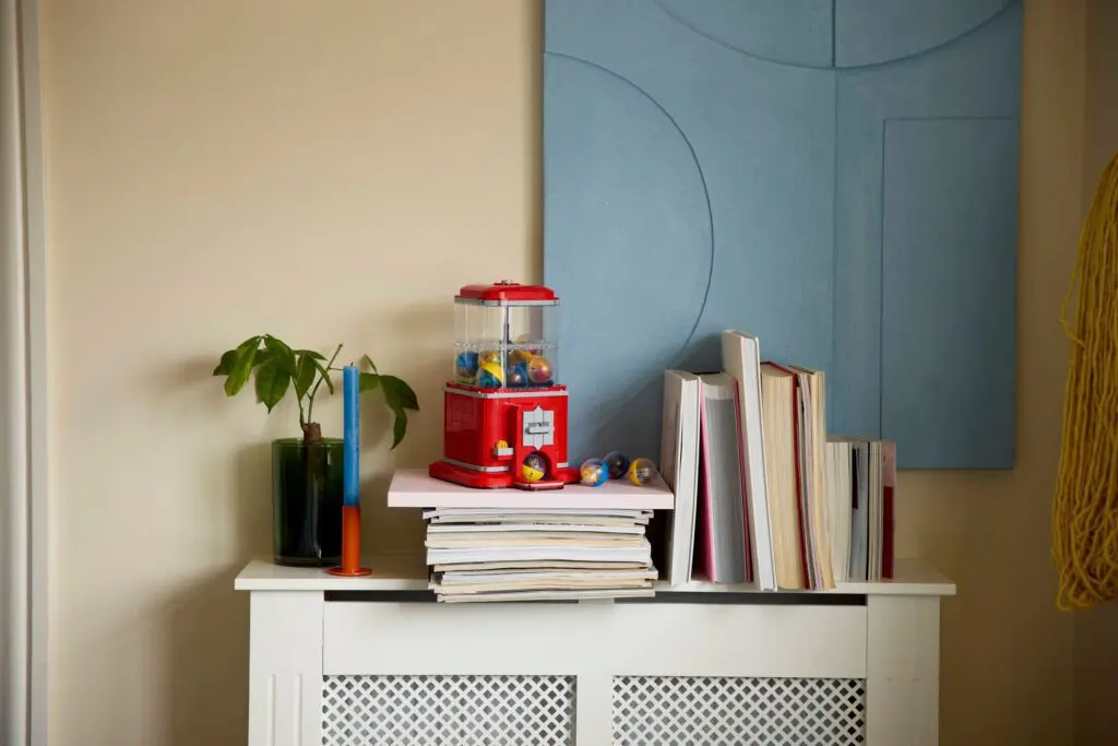 Books and gumball machine on cabinet