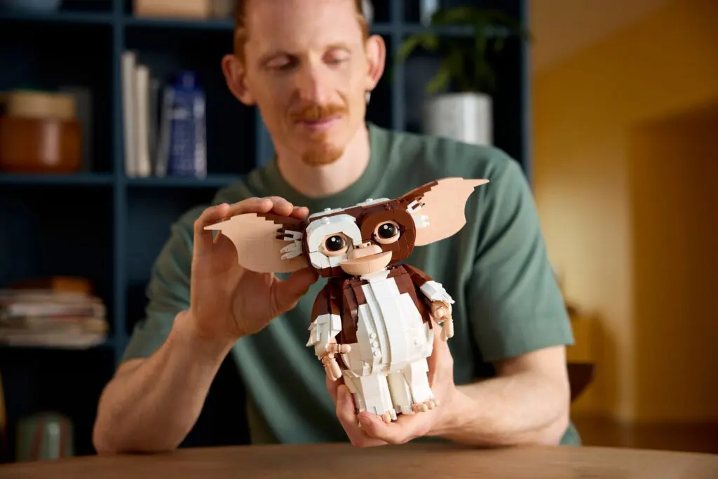 Man assembling a Gremlins LEGO model