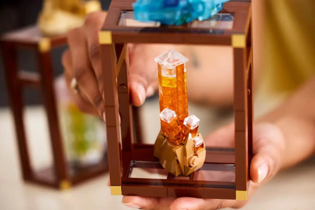 Hands holding a Lego crystal sculpture