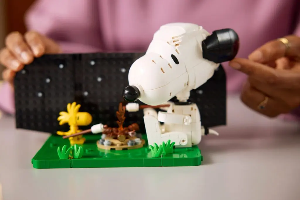 Hands assembling Snoopy LEGO set