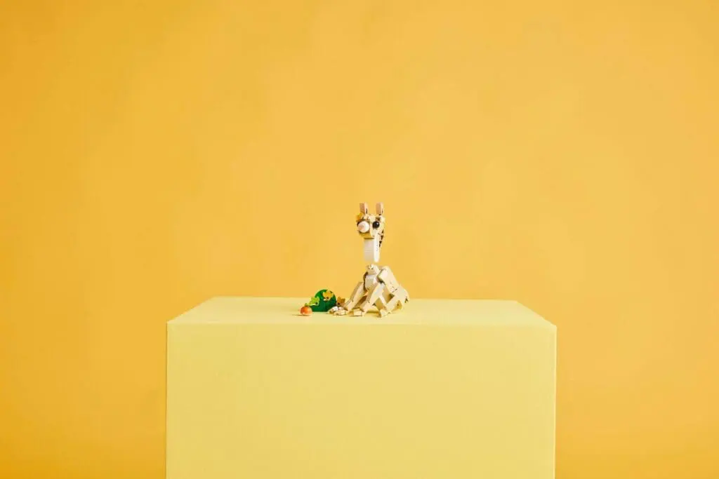 Small robot on yellow background stand
