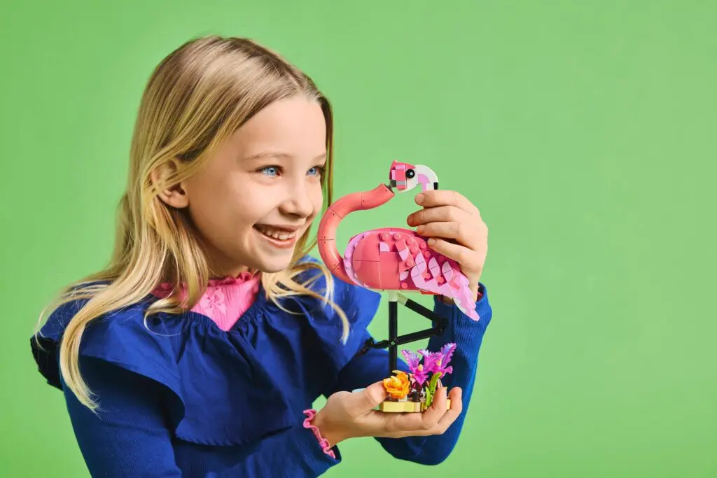 Girl smiling with LEGO flamingo set