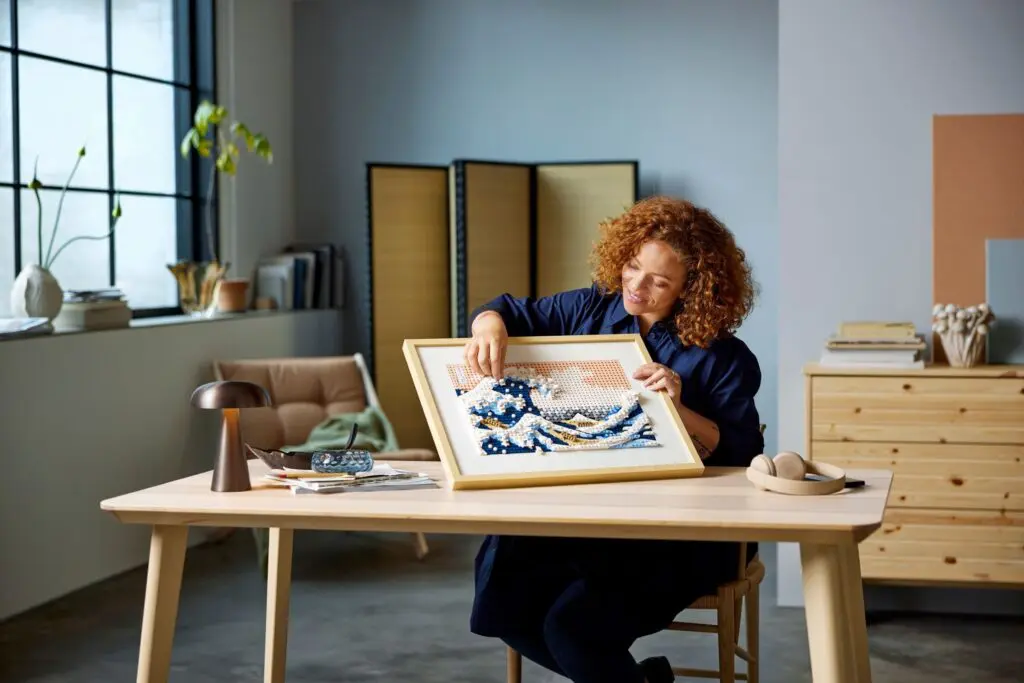 Artist with framed art piece indoors