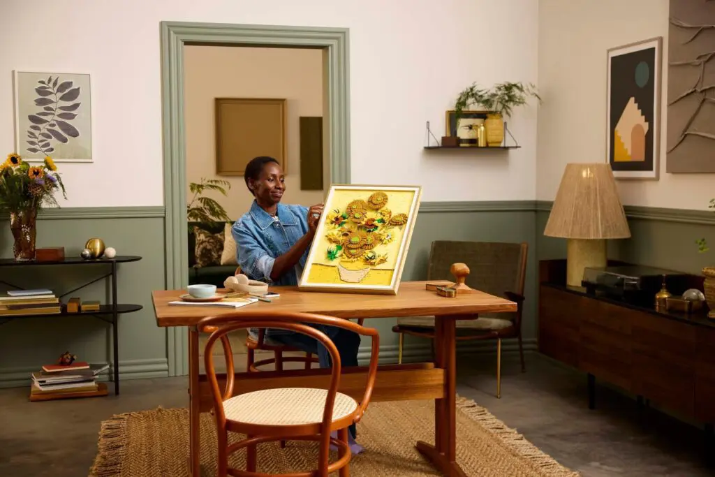 Individual holding framed art at home