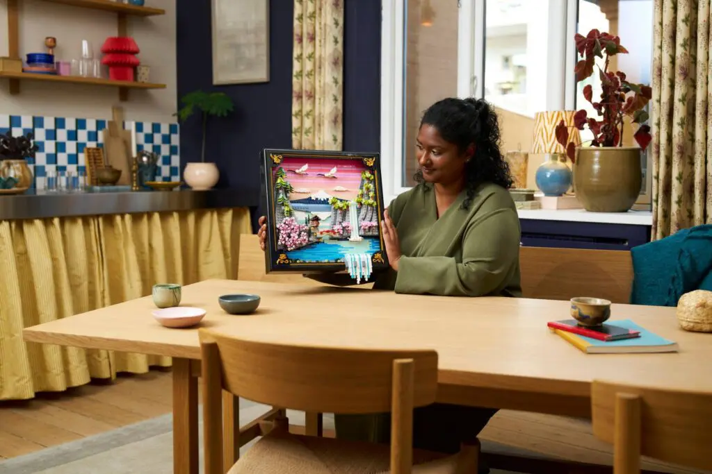 Woman displaying colorful framed artwork