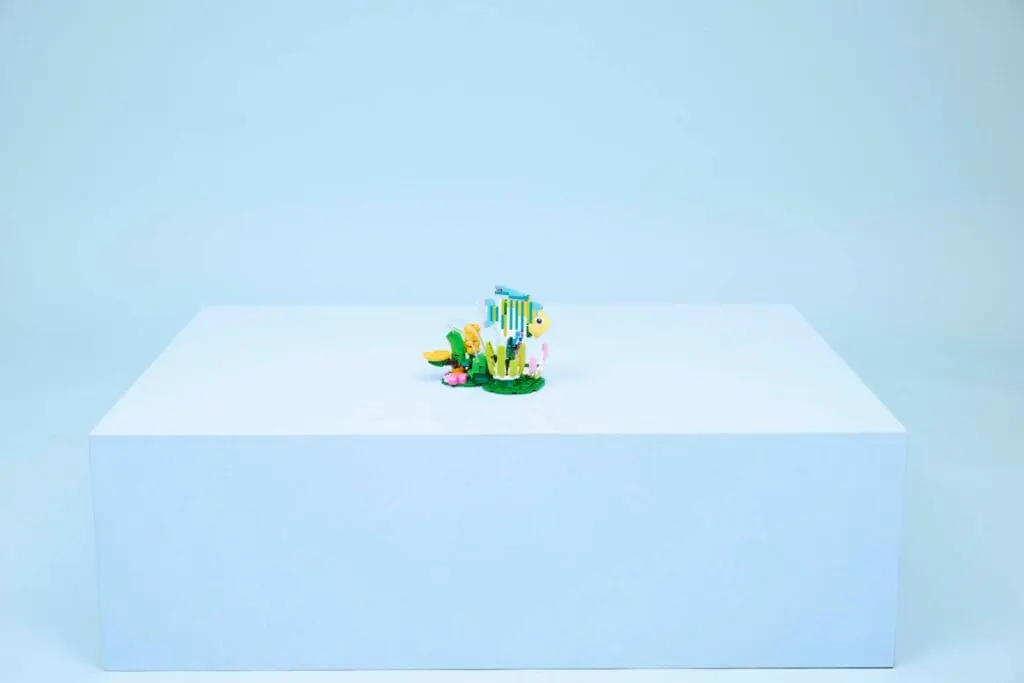 Colorful fish sculpture on a white pedestal.