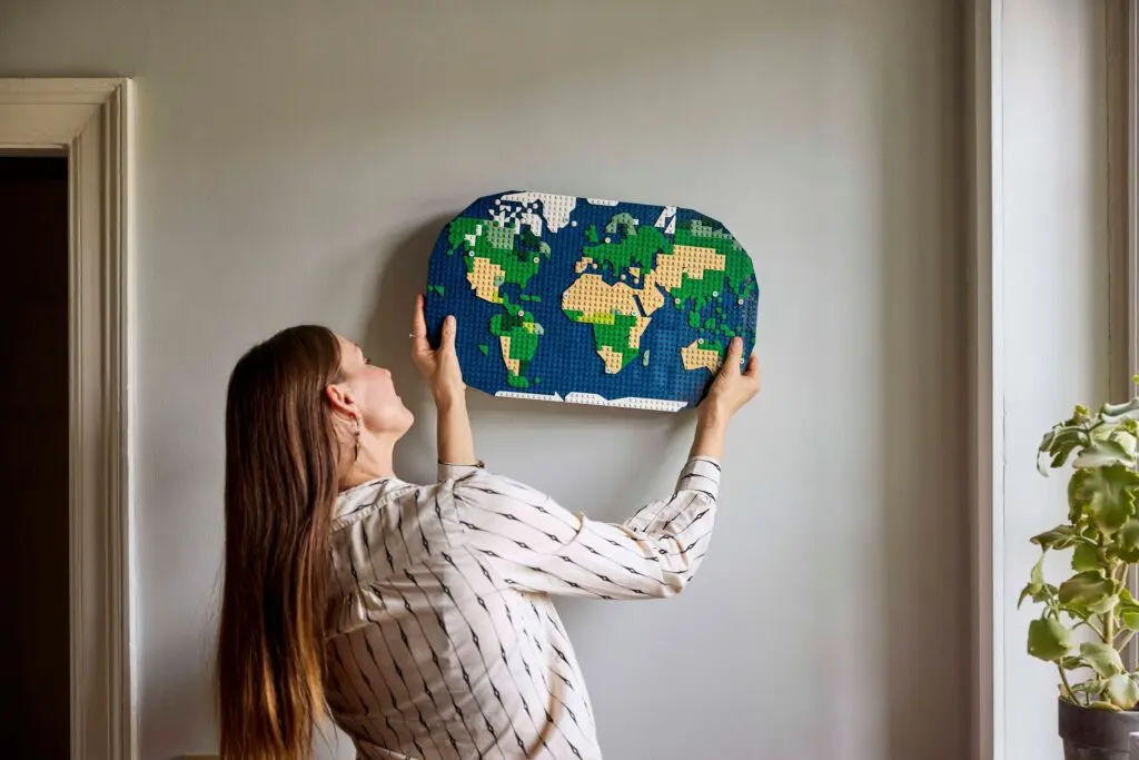 Woman hanging a world map artwork