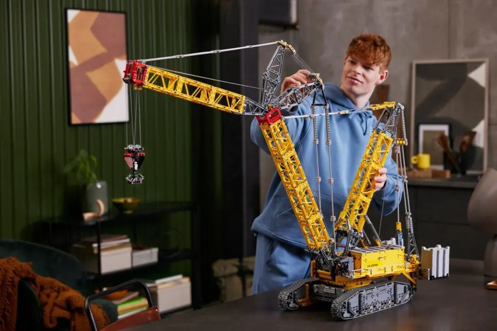 Person assembling a large crane model