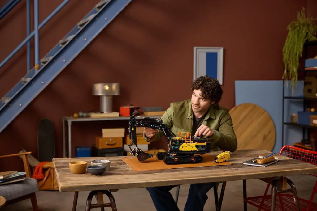 Man assembling toy construction vehicle indoors