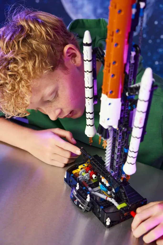 Kid focused on constructing toy spaceship