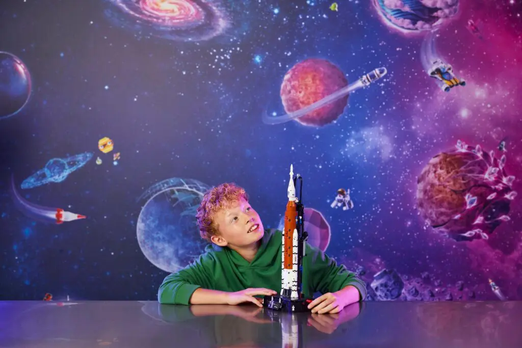 Boy gazing at rocket in cosmic setting
