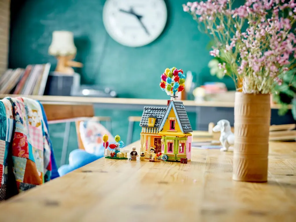 Toy house with balloons on table
