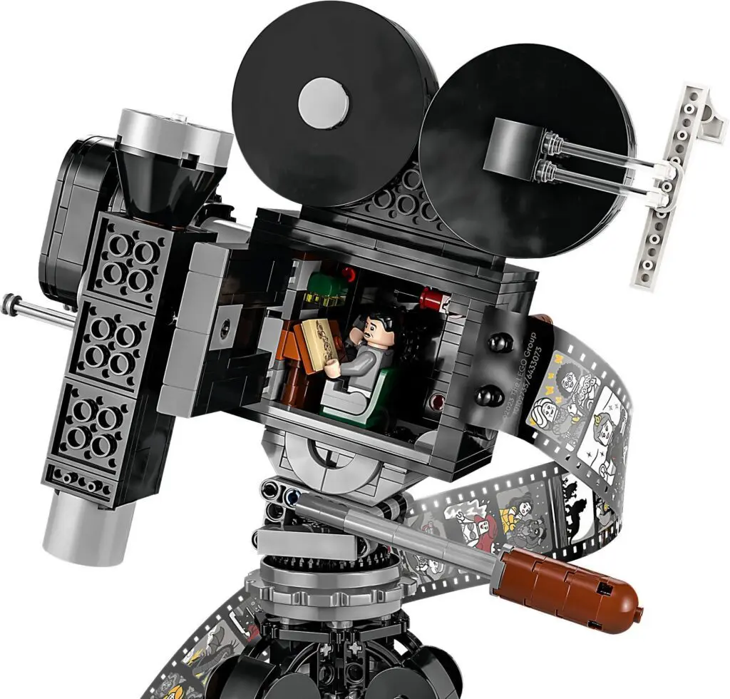 Miniature LEGO camera on tripod stand.